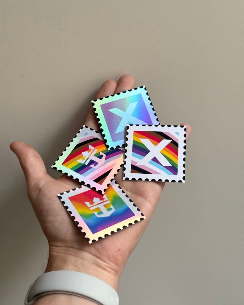 Hands holding three rainbow-colored stamp cards with a bold white X in the center against a light background