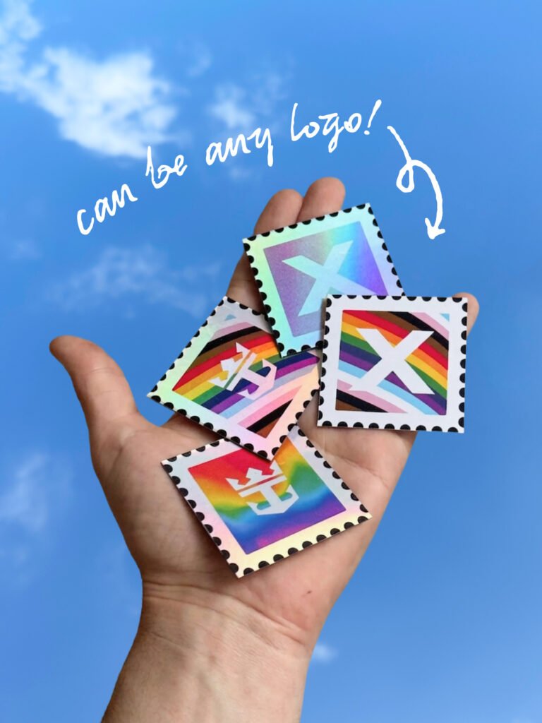 Hand holding several rainbow-colored stamp cards with white X logos against a blue sky